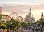 Parc d'attractions européen au coucher du soleil avec montagnes russes et château de conte de fées