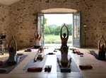 Groupe pratiquant le yoga lors d'une retraite bien-être dans une ferme de campagne en France